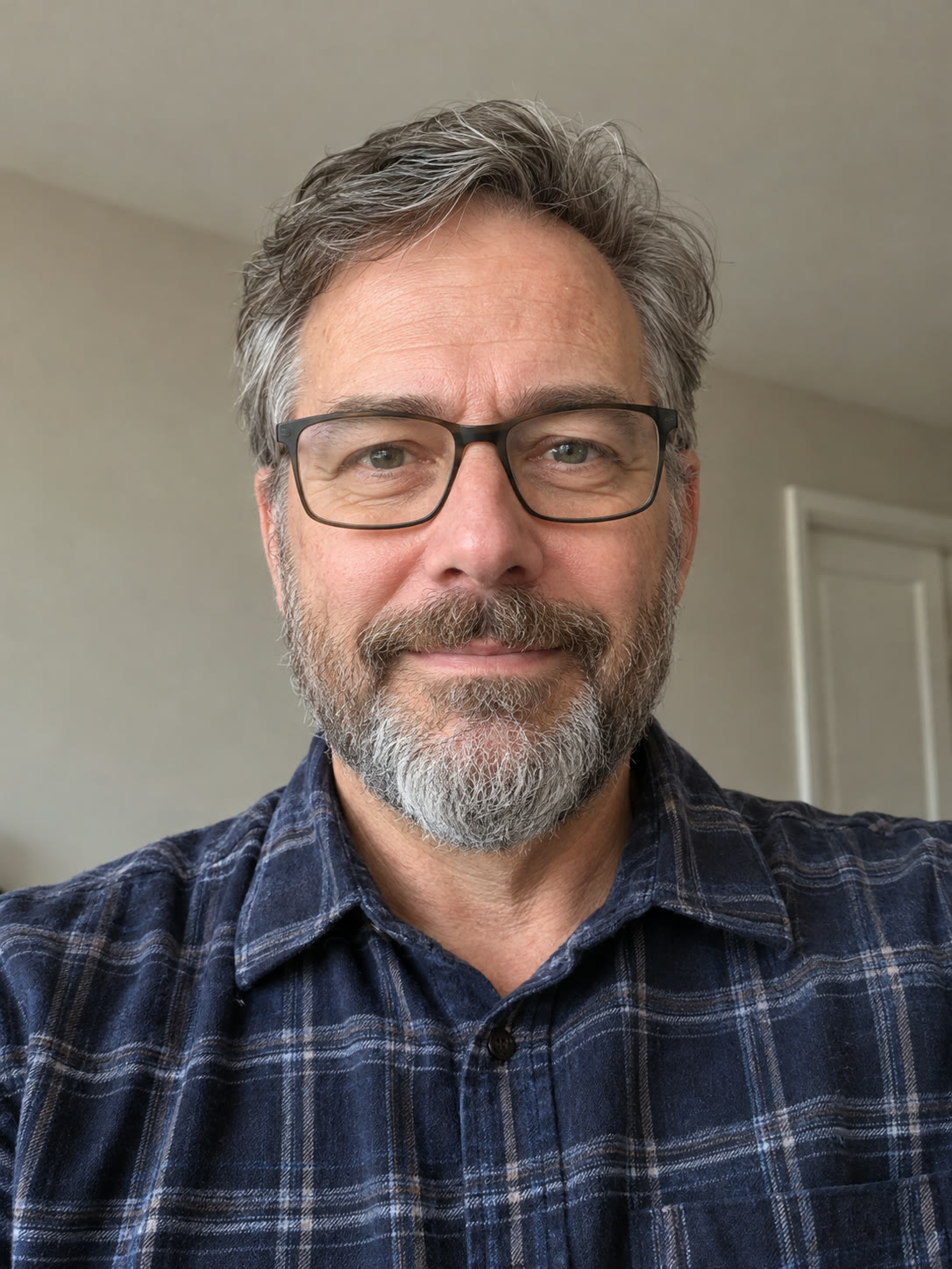 Photo 3: a man with a grey beard and glasses in a navy plaid shirt, the sax player